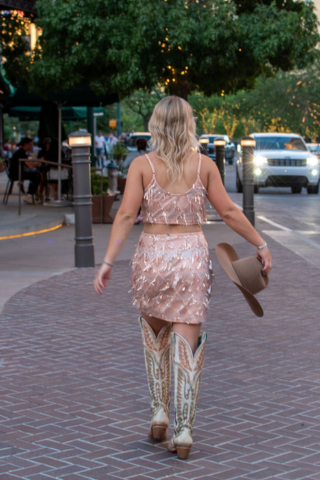 Vegas Nights + Rodeo Lights: The NFR Collection. Two piece chandelier fringe skirt and top paired with cowboy hat. rose gold sequins. 