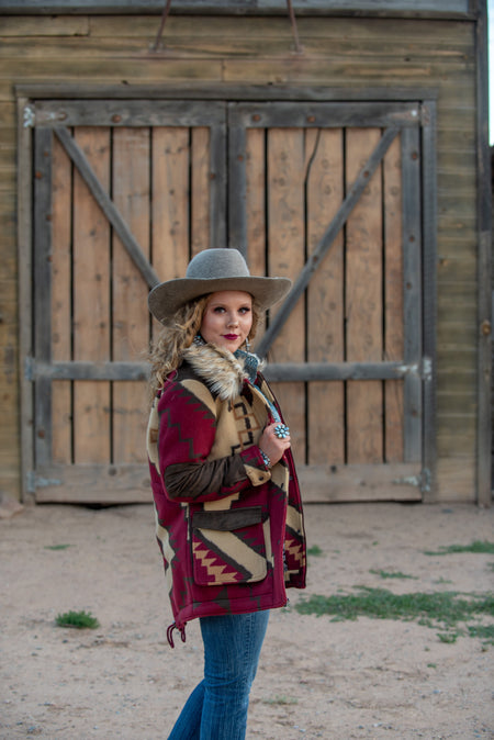 Tasha Polizzi bridget jacket in burgundy. Aztec print, jacket with faux fur collar.  These Tasha Polizzi pieces are the definition of high fashion on the ranch. This burgundy mid length coat has a stunning aztec pattern and fur trim on the collar and cuffs, making for a truly one of a kind jacket.