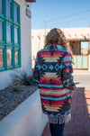 This car coat is truly one of a kind. With its bold aztec print and fringe detailing, it's sure to be a piece that you'll reach for time and time again. It's also a perfect mid-weight fabric for transitioning into spring.   As with all of our pieces by Rhonda Stark Designs, this piece is handmade in the USA and the fabric comes directly from Italy. 