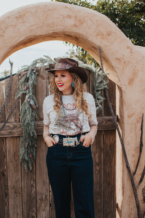 I know what I'm asking Santa for this year! This comfy graphic tee features a buckin' bronco and a festive Christmas tree. It's giving the perfect cowboy Christmas vibes.  Our favorite style pick? Pairing it with our rhinestone cowgirl mesh top to elevate your whole look!