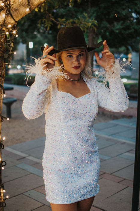 Vegas Nights + Rodeo Lights: The NFR Collection. white sequin + iridescent sequin midi dress with feather trim.