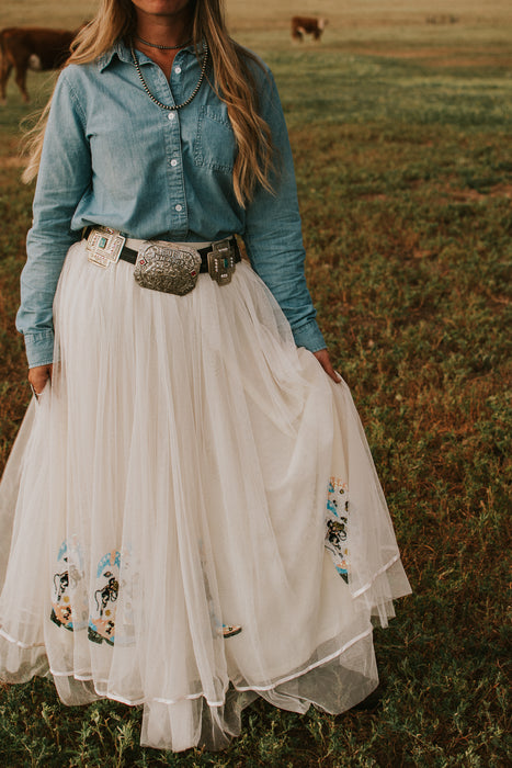 Our Nashville skirt is what dreams are made of! This full length skirt has layers of white tulle and is embellished with sequin cowboy boots. Perfect for styling and twirling!