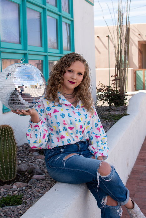 Girls just wanna have fun... outfits, and this top is about as fun as it gets. This blouse has a graphic print with disco balls, cowboy hats and tequila bottles. This shirt is SO flattering while still being super comfortable.